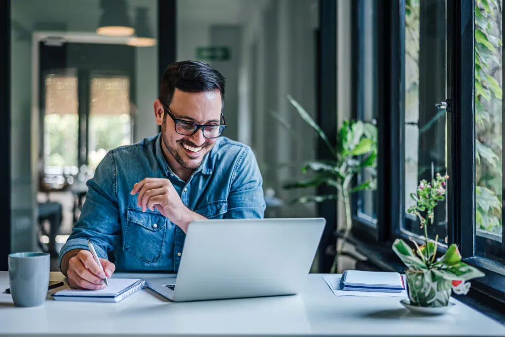 Un responsable prend des notes devant son ordinateur portable